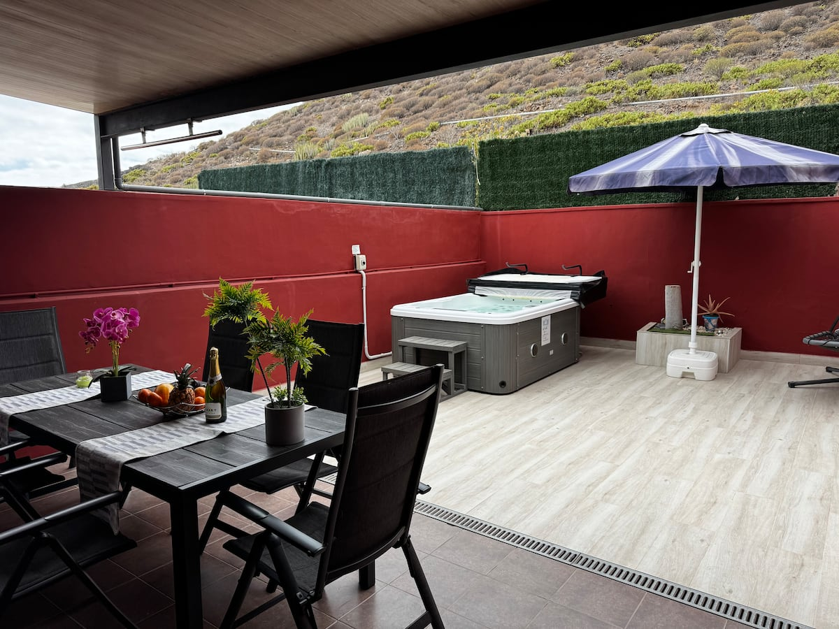 Terrace with table, parasol and hot tub