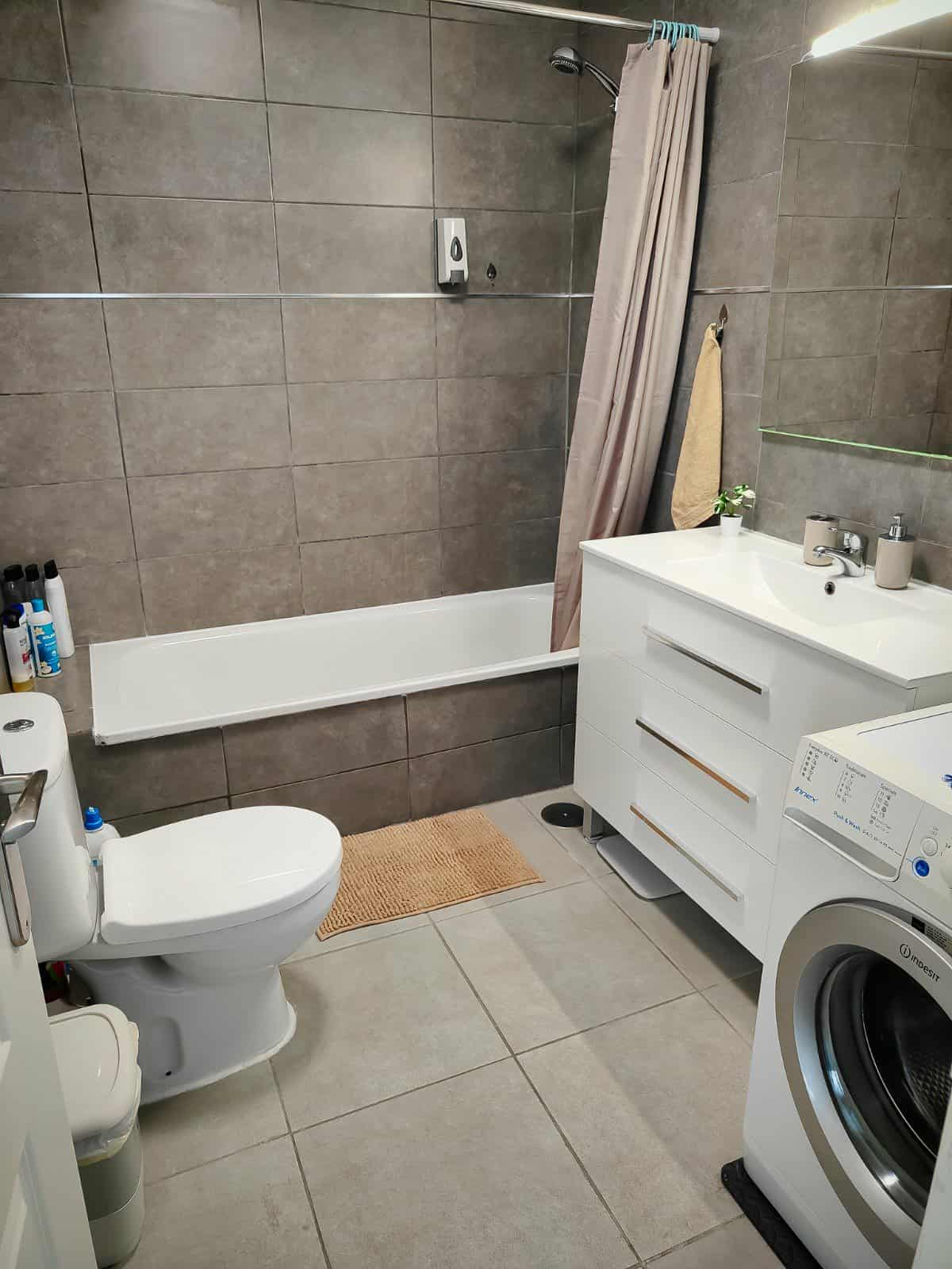 Bathroom with bathtub and washing machine