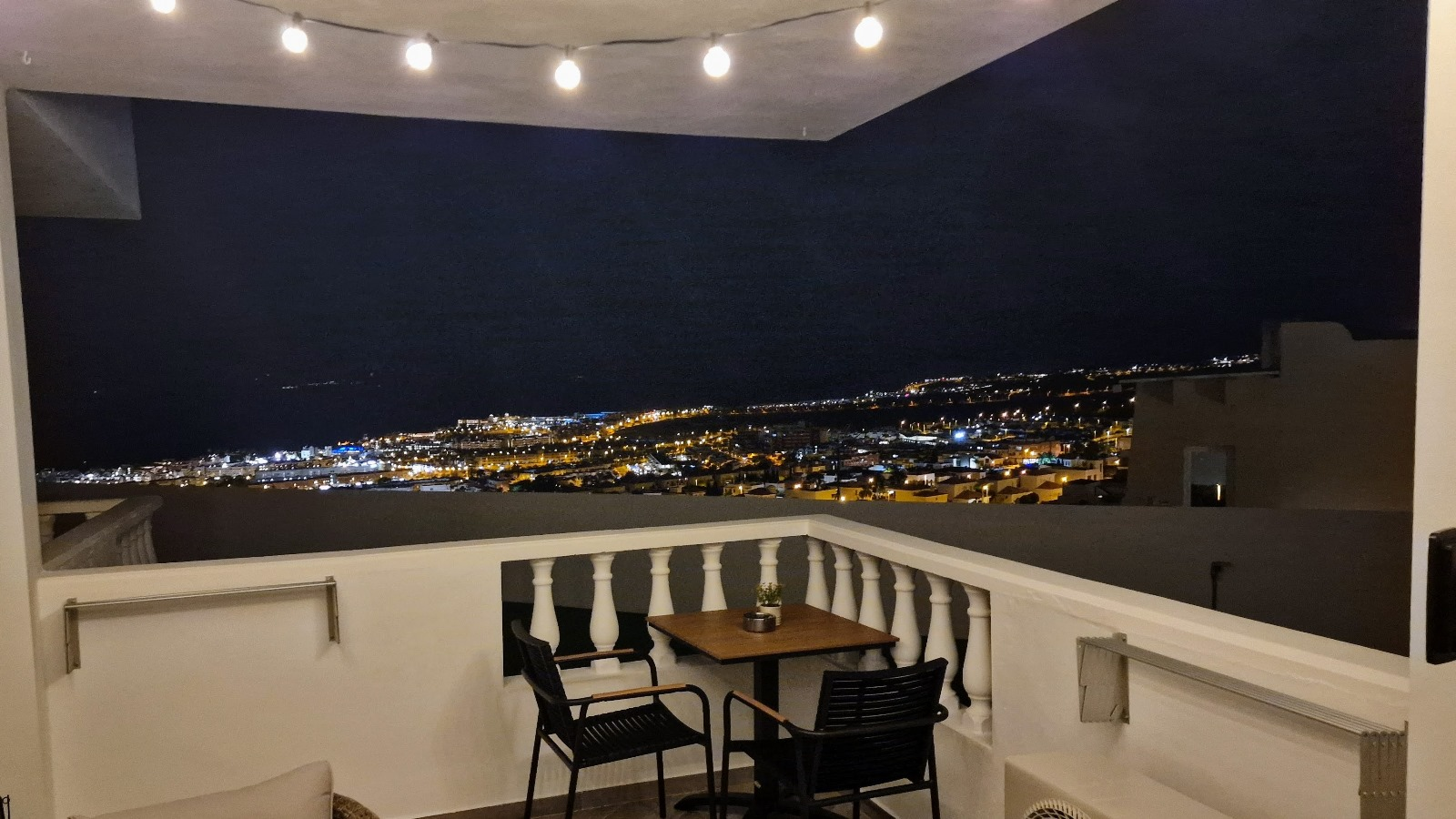 The terrace at night, town lights below