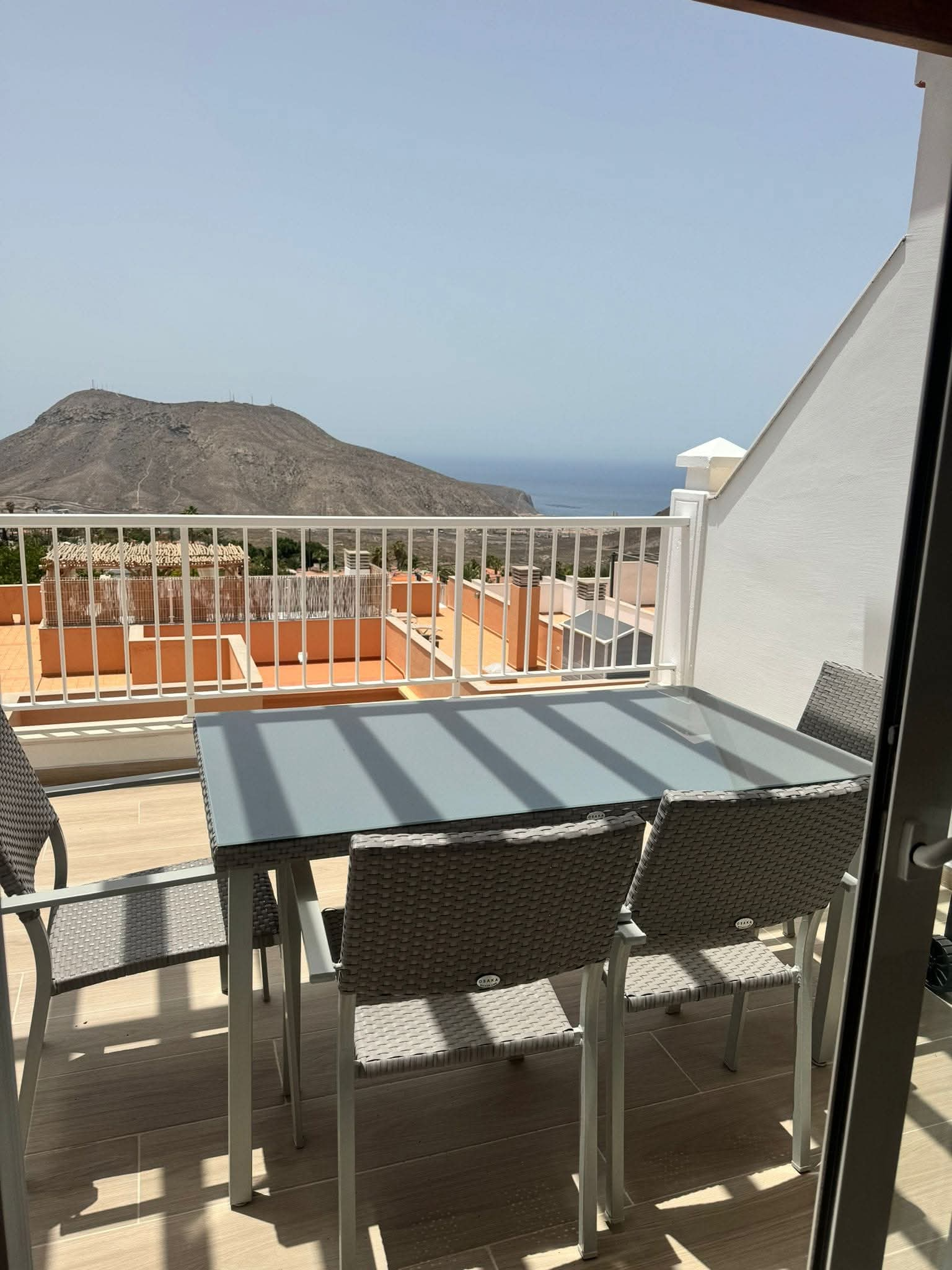 Terrace with table and chairs, mountain behind